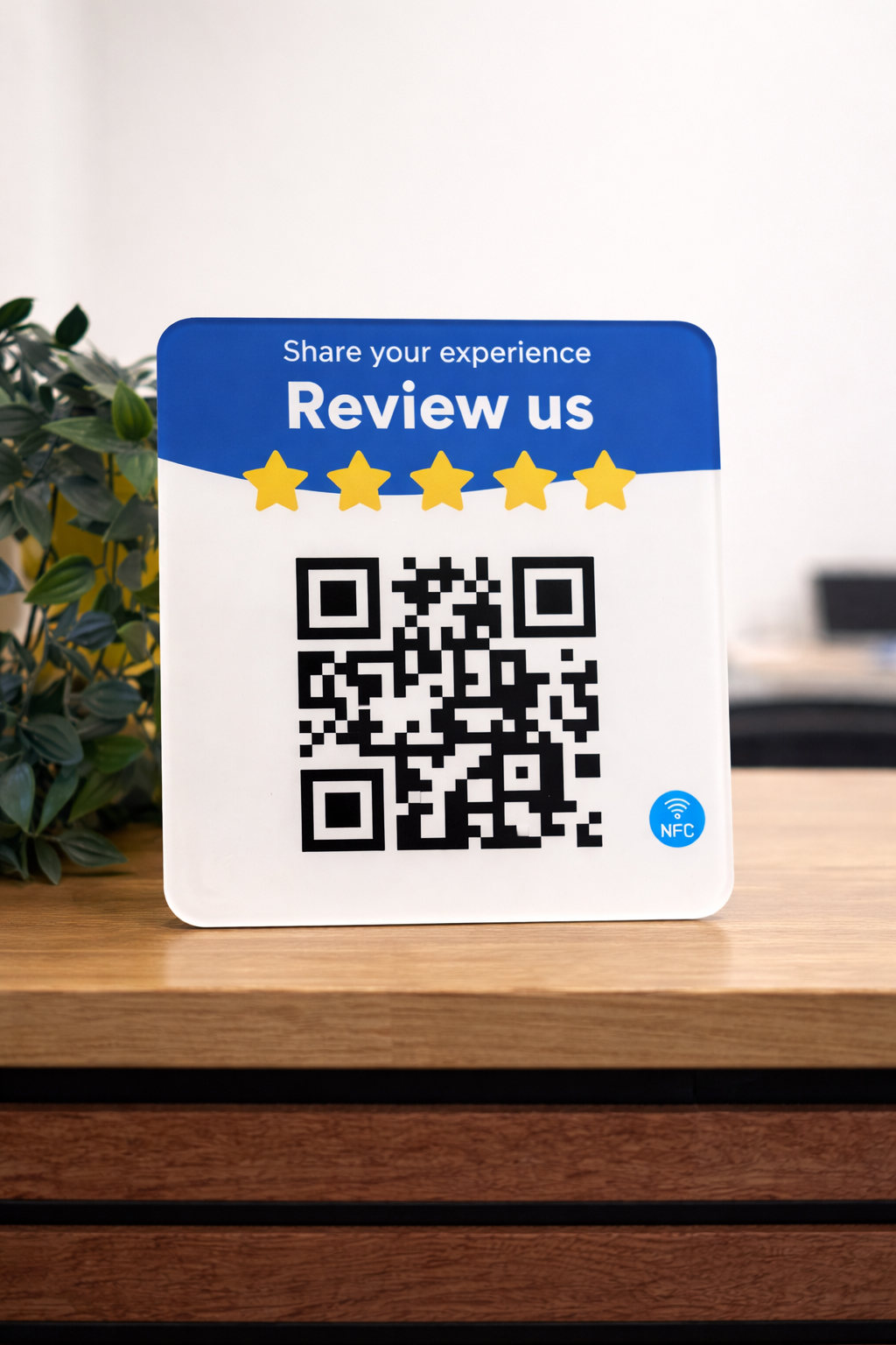 QRbird review badge on a wooden desk — Share your experience, Review us, with QR code and NFC tag